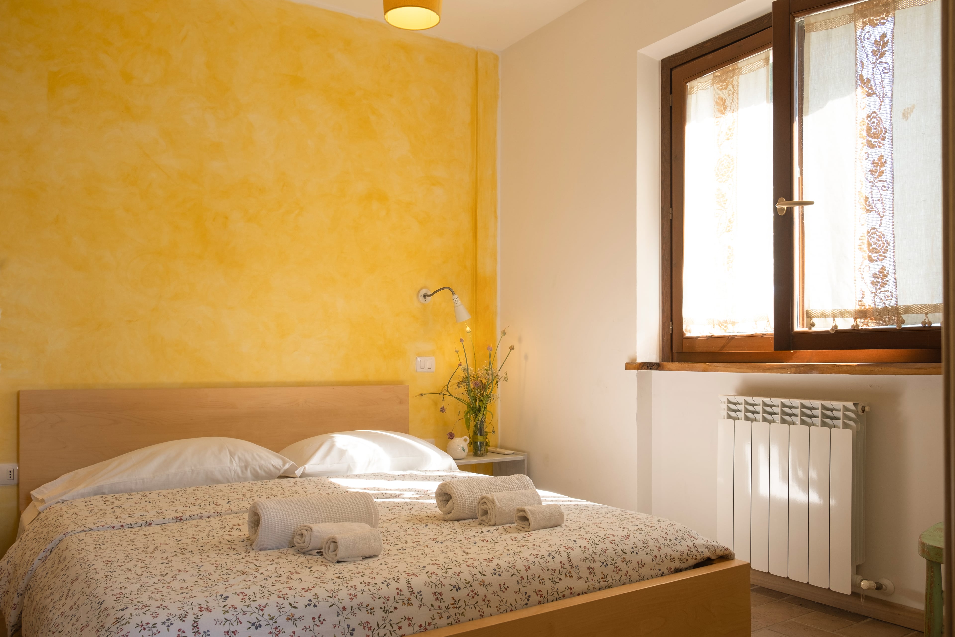 Camera con testiera in legno e finestra