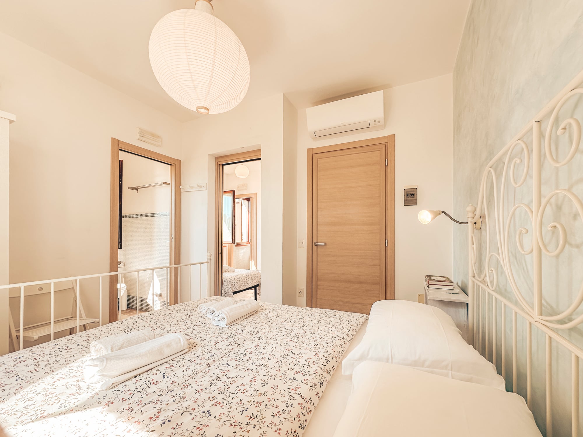 Camera comunicante con lampada di carta e letto matrimoniale