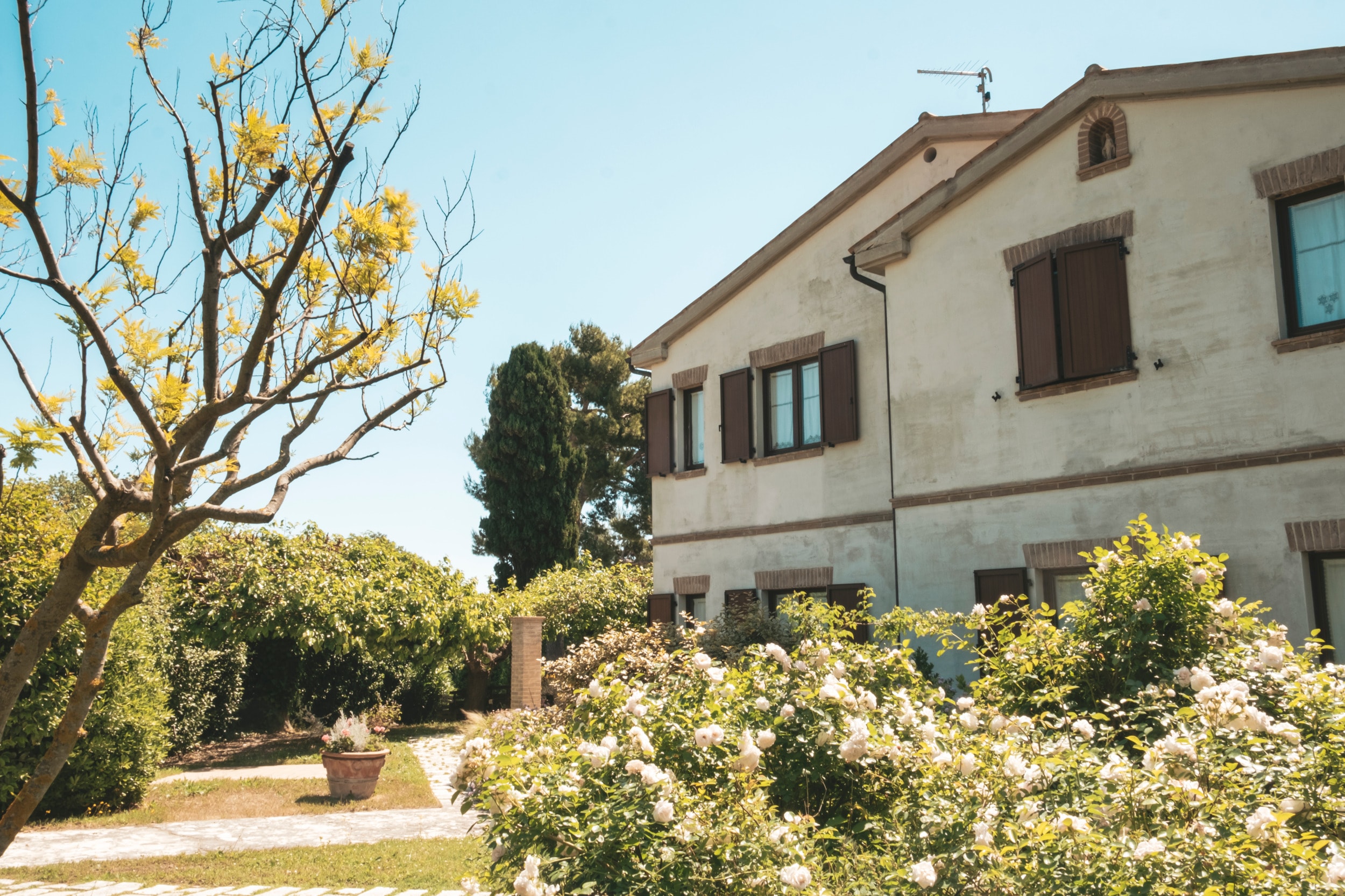 La casa di Mare Verde circondata da fiori e dal verde del giardino