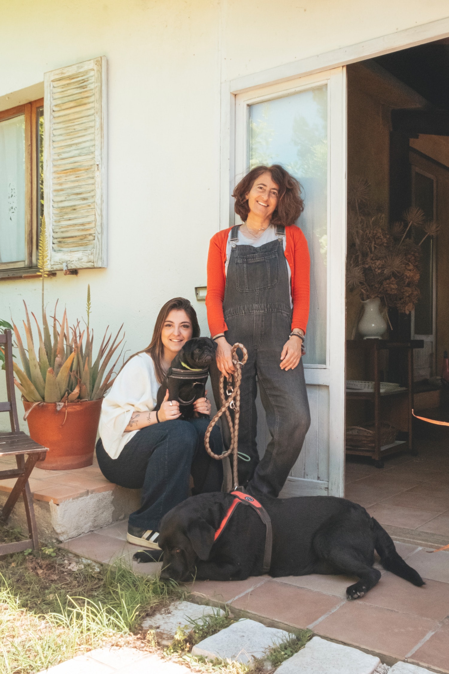 Le gestrici con i loro cani davanti alla casa